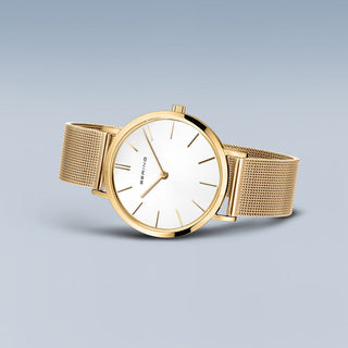 Gold watch with a white face on a light gray background