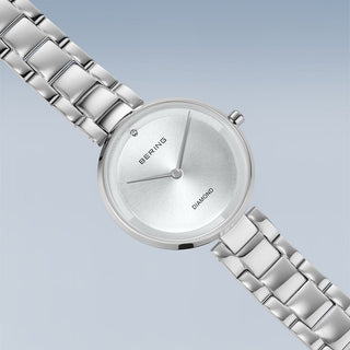Silver Bering watch with a metal strap on a light blue background