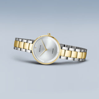 Two-tone watch with gold and silver band on a light gray background