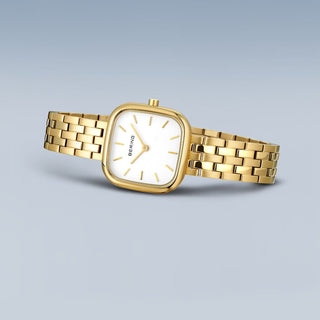 Gold watch with a white face on a light gray background