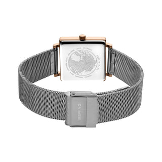 Silver watch with a mesh band and rose gold accents on a white background