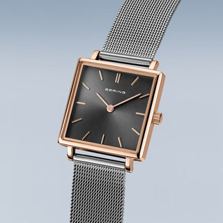 Bering watch with rose gold case and silver mesh band on a gradient background