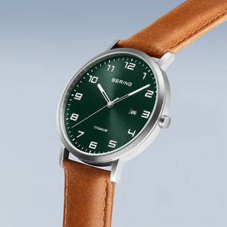 Watch with green dial and brown leather strap on a light gray background