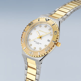 Two-tone gold and silver watch with a white dial on a light gray background