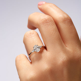 Hand wearing a diamond ring on a light background
