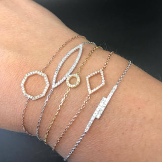 Close-up of a wrist wearing multiple diamond-encrusted bracelets on a dark background