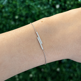 18ct white gold bracelet on a wrist with a green blurred background