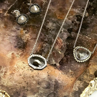 Jewelry set with necklace and earrings on a textured stone surface