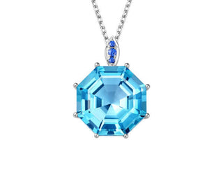 A large octagon-shaped pendant featuring a central blue topaz with surrounding blue sapphires, set in 18ct white gold.