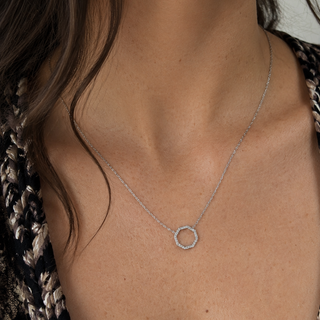 Necklace with a circular pendant worn by a person