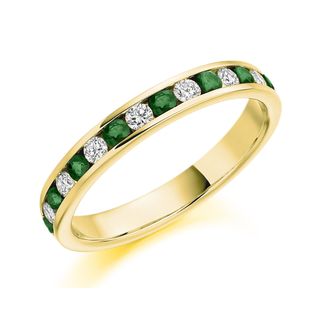 Gold ring with green gemstones and diamonds on a white background