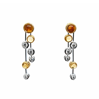 Pair of earrings with amber and silver stones on a white background