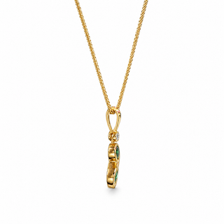 A gold chain necklace with a small pendant featuring green gemstone accents, shown against a plain white background.