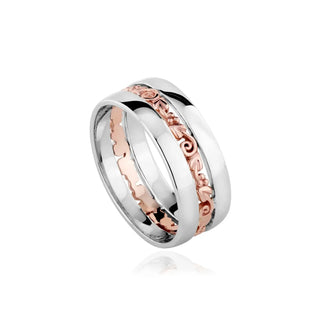 A silver band ring with rose gold Tree of Life design elements, featuring intricate patterns and textures.