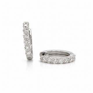 A pair of small silver hoop earrings set with a row of clear round-cut stones, shown from side and front angles on a white background.