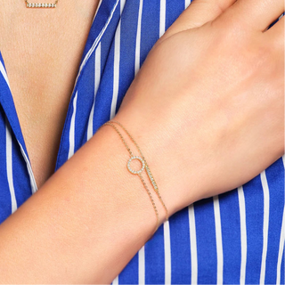 Person wearing a blue and white striped shirt with gold jewelry