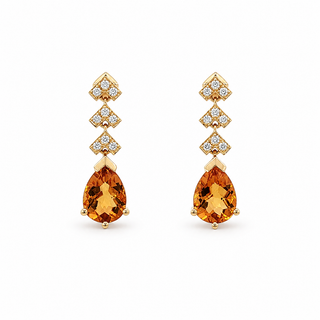 A pair of gold drop earrings featuring pear-cut orange citrine gemstones at the bottom, with three smaller diamond-cut sections above set with clear round and marquise-cut stones, shown on a plain white background.
