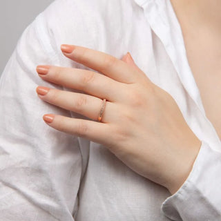 Hand wearing a ring on a light gray background