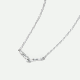 Silver necklace with baguette cut diamonds on a light gray background