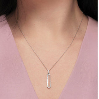 Silver necklace with a pendant on a person wearing a pink top