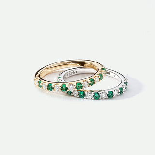 Two gold rings with emerald and diamond accents on a white background