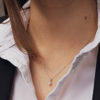 Close-up of a person wearing a delicate necklace with a small pendant.
