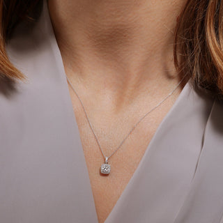 Necklace with a pendant worn by a person, focusing on the jewelry against a neutral background.