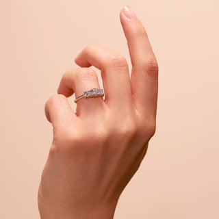 Hand wearing a diamond ring on a beige background
