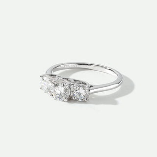 Three-stone diamond ring on a light gray background