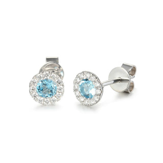 Pair of white gold earrings with aqua gemstones on a white background