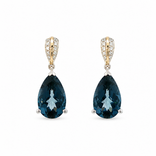 A pair of pear-shaped drop earrings featuring deep blue gemstones in yellow gold and white gold settings with pavé diamonds, shown on a plain white background.