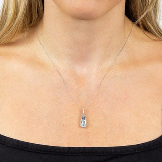 Teardrop-shaped pendant necklace on a person wearing a black top.