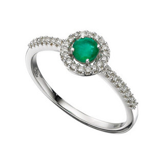 A 9ct white gold emerald and diamond halo ring with a round brilliant cut emerald in the center surrounded by a halo of round brilliant cut diamonds.