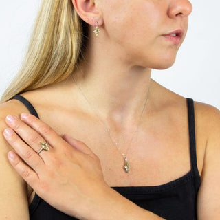 Woman wearing a necklace with a small pendant, close-up on a plain background
