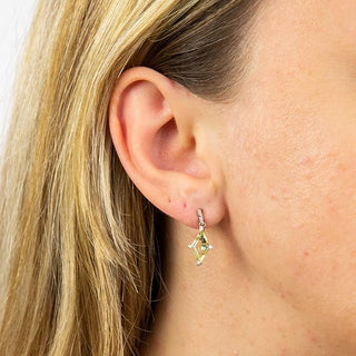 Close-up of a person wearing a yellow gemstone earring.