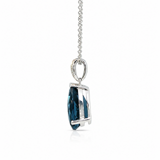A silver pendant necklace featuring a faceted dark blue marquise-cut gemstone in a silver bezel setting, suspended from a delicate silver chain against a white background.