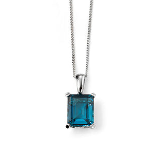 Blue gemstone pendant on a silver chain against a white background