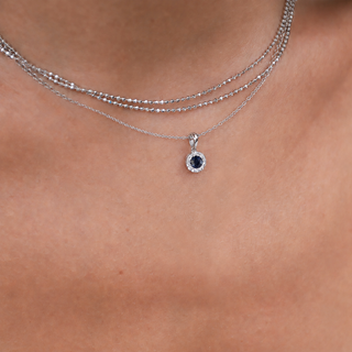 Silver necklace with a pendant on a person's neck