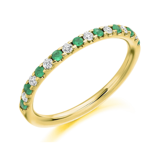 Gold ring with emeralds and diamonds on a white background