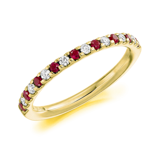 Gold ring with red gemstones and clear stones on a white background