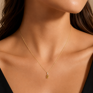 Gold necklace on a model with a neutral background