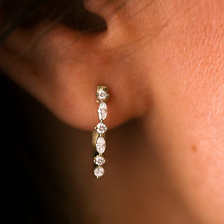 Close-up of a diamond earring on an ear with a blurred background