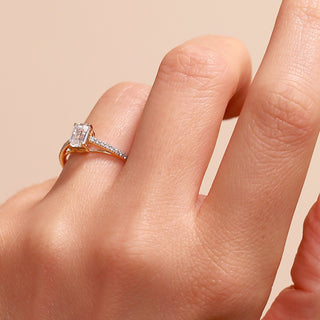 Yellow gold ring with a large diamond on a beige background