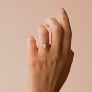 Hand wearing a diamond ring on a beige background