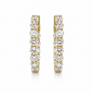 A pair of gold huggie hoop earrings set with multiple round-cut clear gemstones, shown against a plain white background.