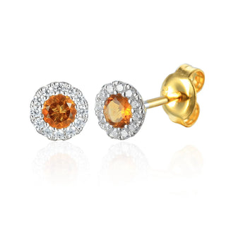 Gold and silver earrings with orange gemstones on a white background