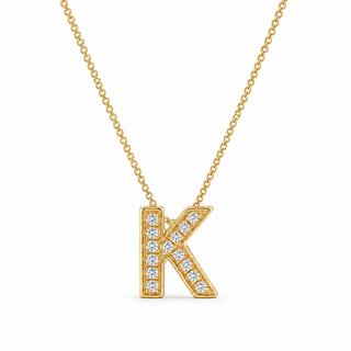 Gold necklace with 'K' pendant on a white background