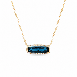 A gold chain necklace with a rectangular bezel-set pendant featuring a deep blue faceted gemstone surrounded by small clear accent stones, shown on a plain white background.