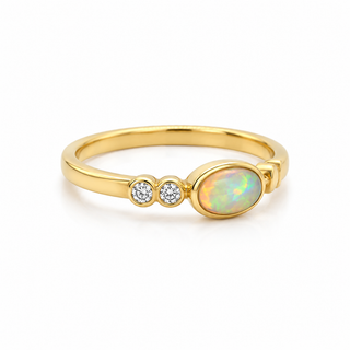 Gold ring with an opal stone and two small diamonds on a white background