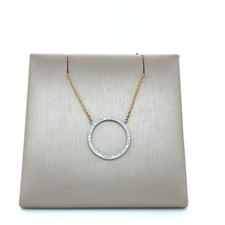Gold necklace with a circular pendant on a beige display box